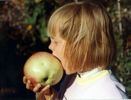Foto Kind beißt in einen Apfel