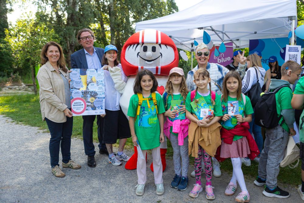 Winkende Volksschulkinder-Gruppe mit grünen Danube-Day-T-Shirts.