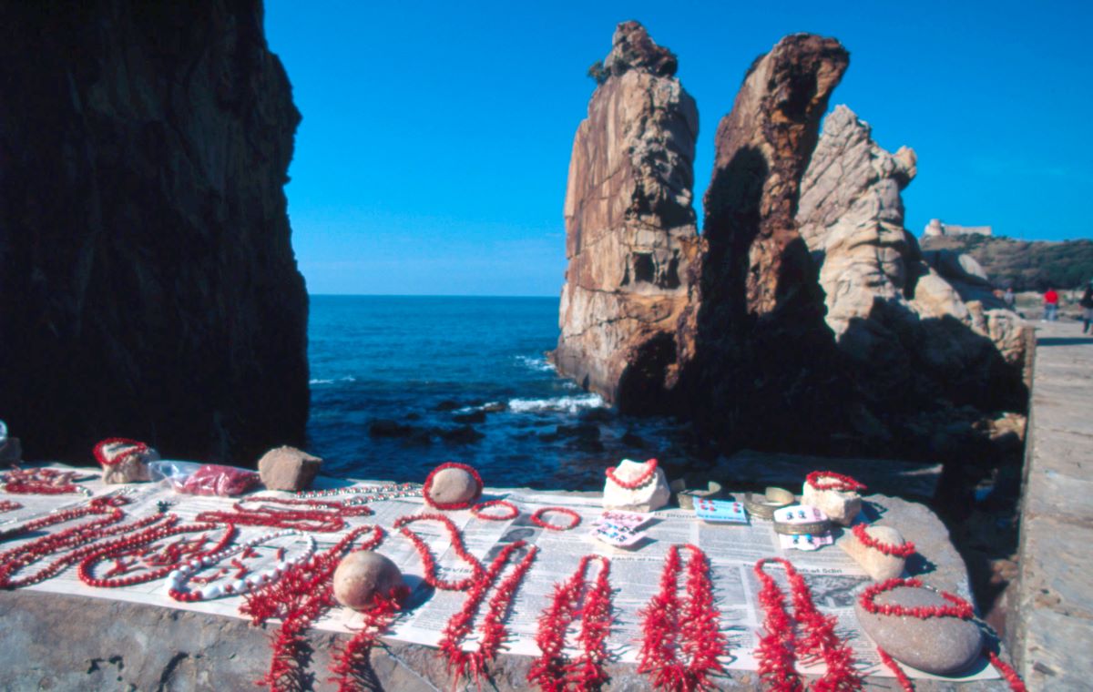 Verkaufsstand am Strand bietet Ketten aus Roter Koralle zum Verkauf an.